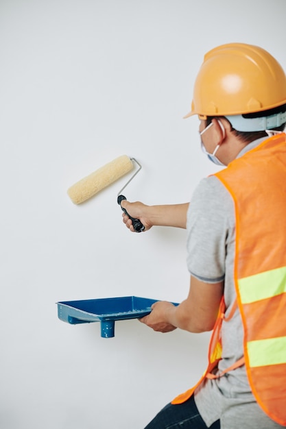 Worker painting walls white