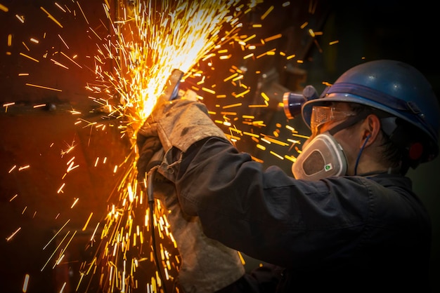 The worker polished the metal splashing sparks