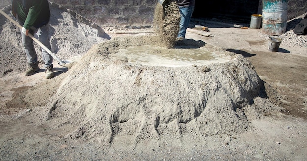 Worker prepare concrete with shovel at construction site