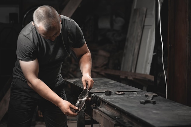 ある労働者が自宅の工房で木工機械を準備し、自分の手で金属製品を作る