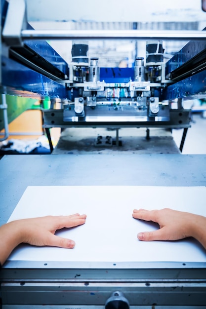 Photo worker preparing print screening metal machine industrial printer manufacture work first person perspective
