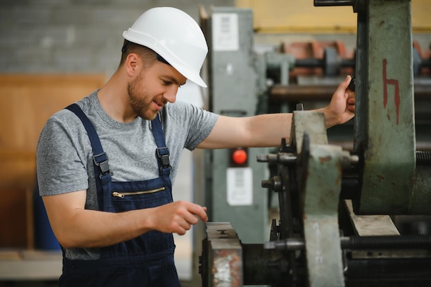 Worker in protective clothing in factory using machine