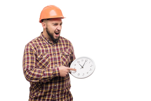 Worker in protective helmet holding alarm clock on white. Time to work. Building construction time