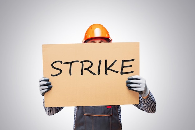 Worker at protest rally holding home made placard sign man activist during a protest in workplace