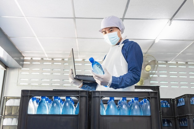 worker or quality inspector working in checking bottled drinking water in drink water factory