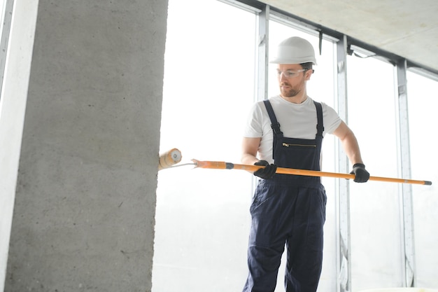 Worker renewing apartment on wall background