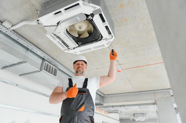 Photo worker repairing ceiling air conditioning unit