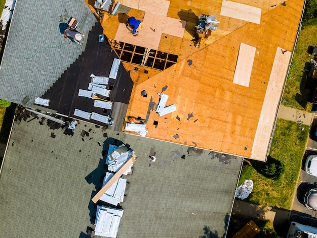 작업자가 집 지붕을 수리하는 집 지붕의 대상 포진을 교체합니다.