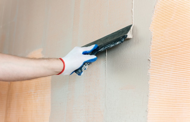 The worker's hand with a wide spatula.