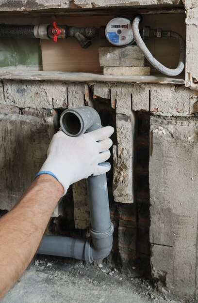 Worker's hands are installing sewer pipes.