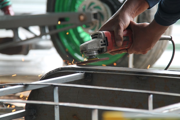 worker sawing metal with a grinder, sparks fly