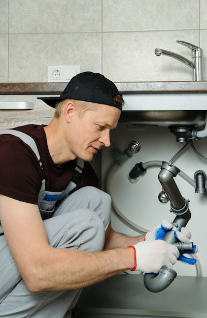 Worker sets trap for kitchen sink