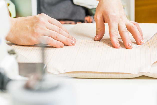 Worker of sewing production uses scissors for cutting of fabric Sewing production line