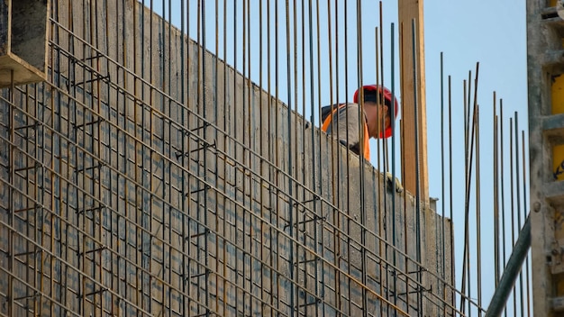 超高層ビル建設現場の青い空を背景に労働者