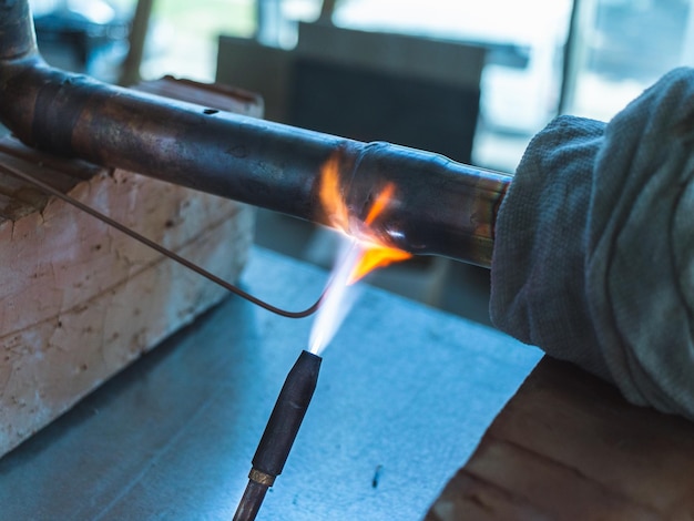 Photo worker soldering a copper pipe