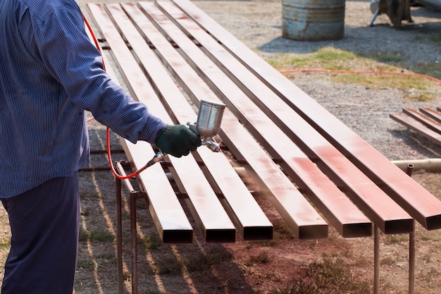 Worker spraying steel bar