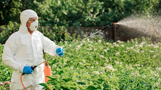 Worker sprays organic pesticides on plants.