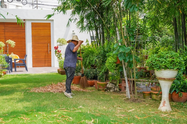 Worker sweeps dry bamboo leafs in the garden