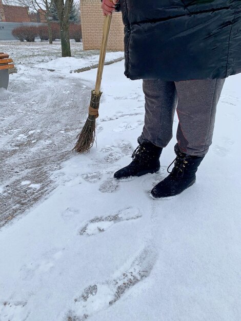 A worker sweeps snow with a broom