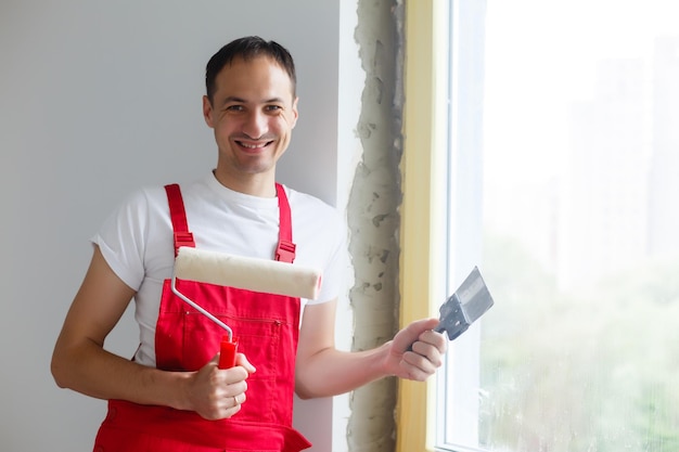 worker in uniform installs a plastic sandwich panel on the slopes of the window