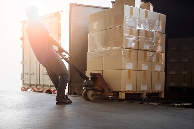 Foto lavoratore che scarica la scatola del pacco fuori dal container di carico interno magazzino di spedizione trasporto logistico