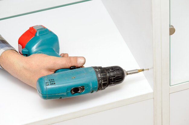 Worker using the electric screwdriver