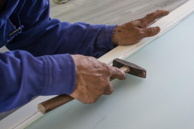 Worker using a hammer in woodwork construction