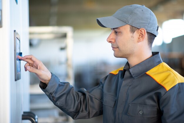 Worker using a touchscreen in a factory