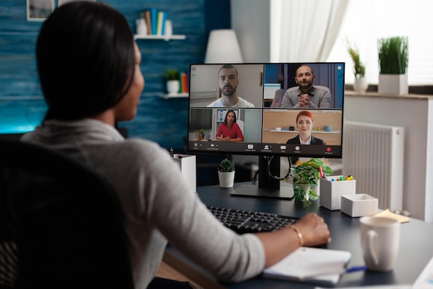 Lavoratore che utilizza la comunicazione in videochiamata con i colleghi per svolgere riunioni di lavoro e lavoro remoto sul computer. adulto che parla di progetto in videoconferenza online su connessione internet.