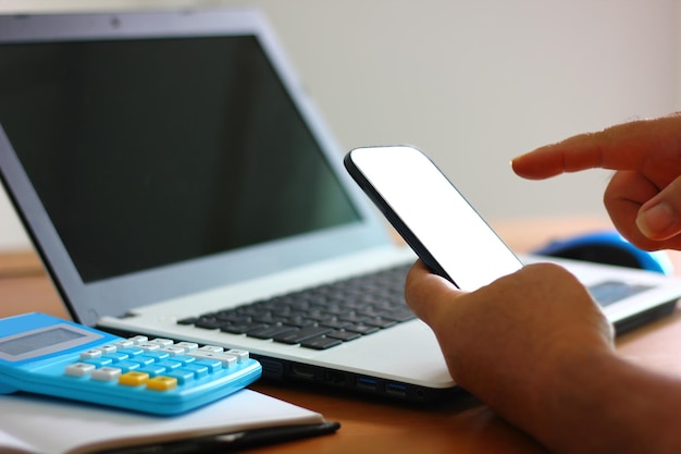 Worker using white screen mobile working with laptop