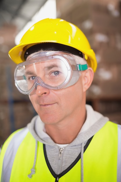 Foto operaio che indossa il casco in magazzino