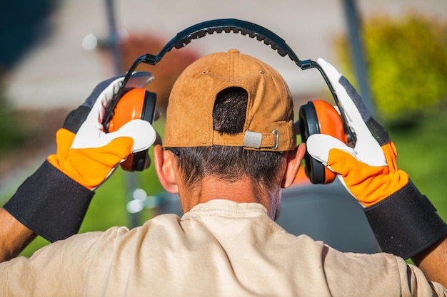 Photo worker wearing noise reduction ear muffs loud noises job