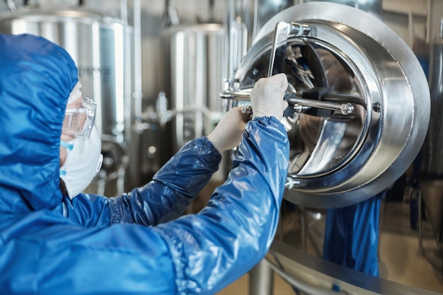 Worker wearing protective suit opening vault lock