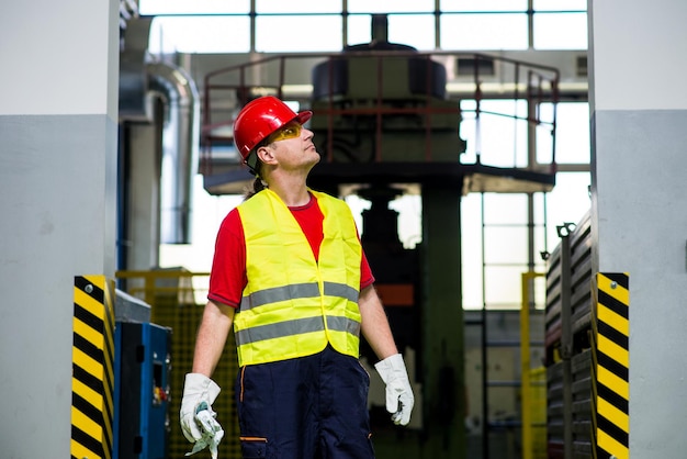 Photo worker wearing reflective west and red helmet