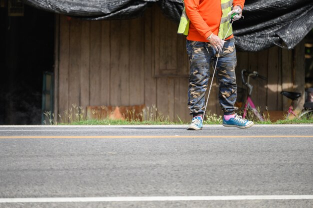 制服を着た労働者は、道路で測定するとストライプ