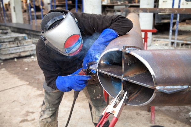 Worker welding in a factory. Welding on an industrial plant.