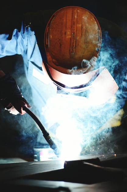 Foto lavoratore di saldatura in fabbrica