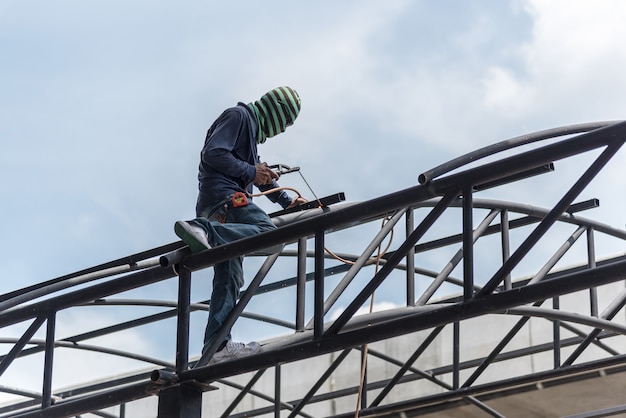 Worker welding the steel part