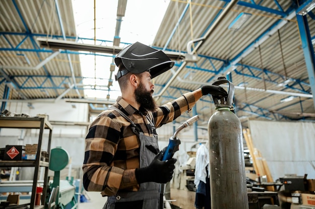 Foto un operaio che salda in officina