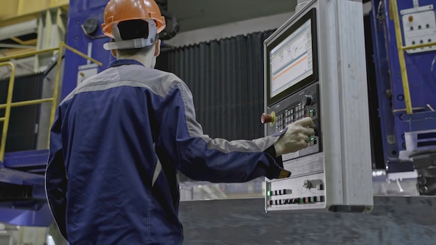 Рабочий с автоматическим измельчением на заводе Рабочий с дистанционным управлением автоматизированной машиной на заводе Конкретная круговая структура вращается на машине с автоматизированным процессом