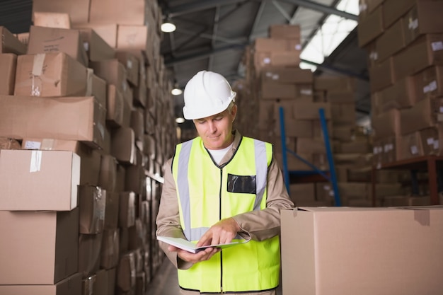 Worker with diary in warehouse