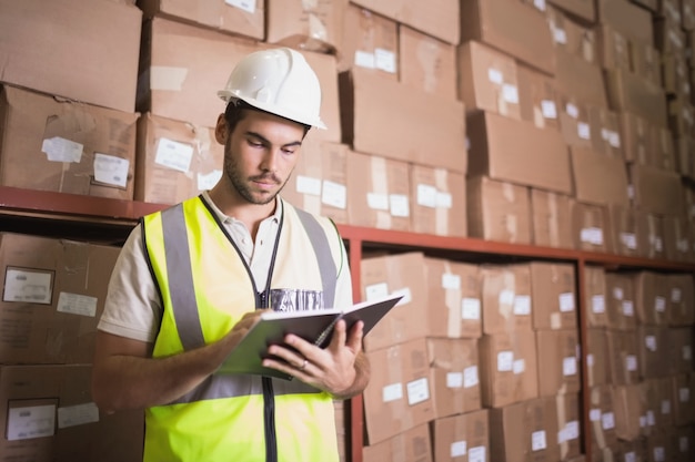 Worker with diary in warehouse