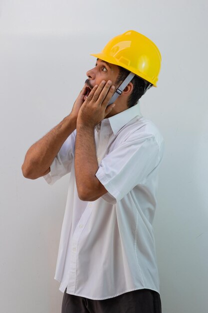 Worker with helmet isolated on white background. Black man in a helmet with surprise expressions.