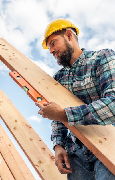 Worker with level checking the roof timber