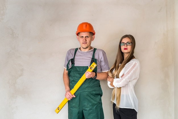 Worker with level tool and beautiful woman