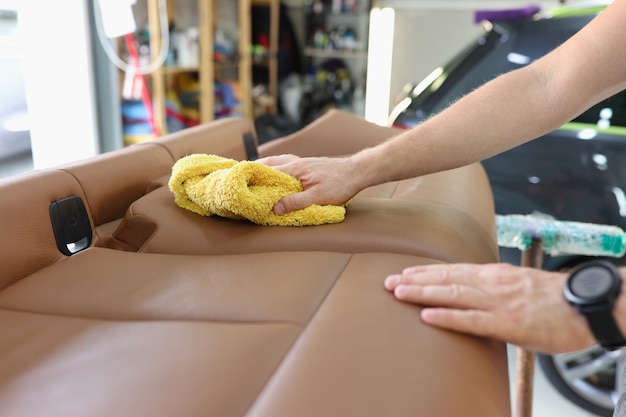 Lavoratore con salviette di straccio rimosso seggiolino auto interno auto lavaggio a secco concept