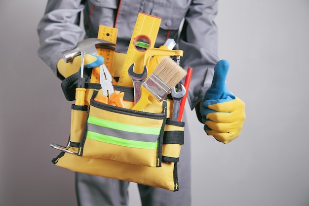 Worker with a tool belt. Construction tools