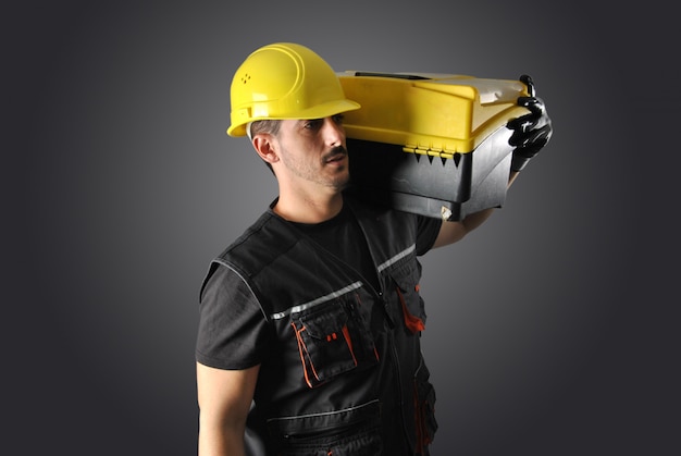 Worker with yellow helmet, drill and hammer