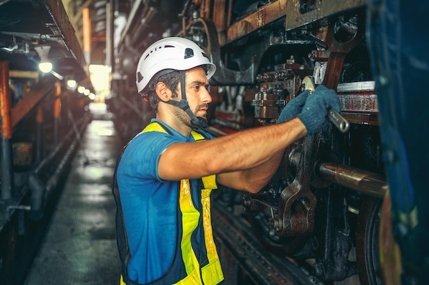 Worker working in industrial factory uses a cross screwdriver to inspect the machine