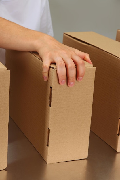 Worker working with boxes at conveyor belt on grey background